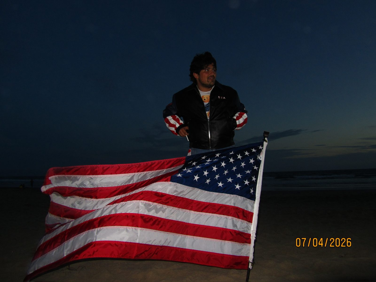 Cruz Paxton on the beach with a flag